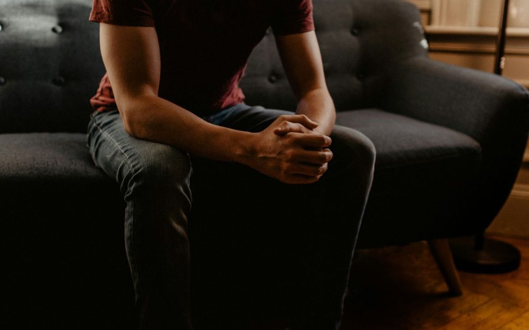 Man sitting on a sofa in what looks like a therapy room