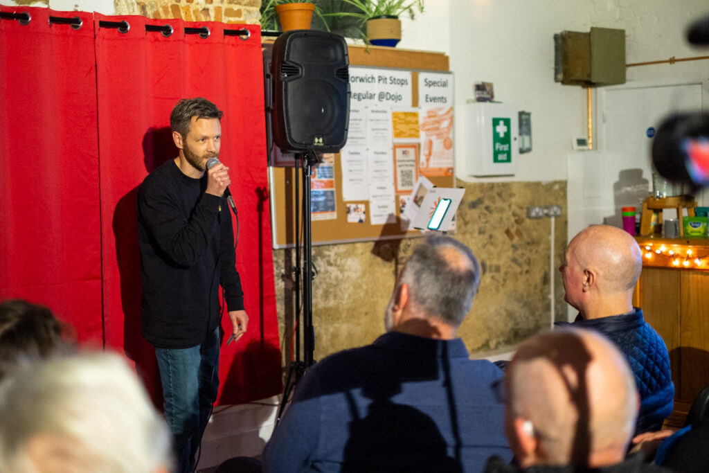 A man performing at MensLaugh comedy showcase